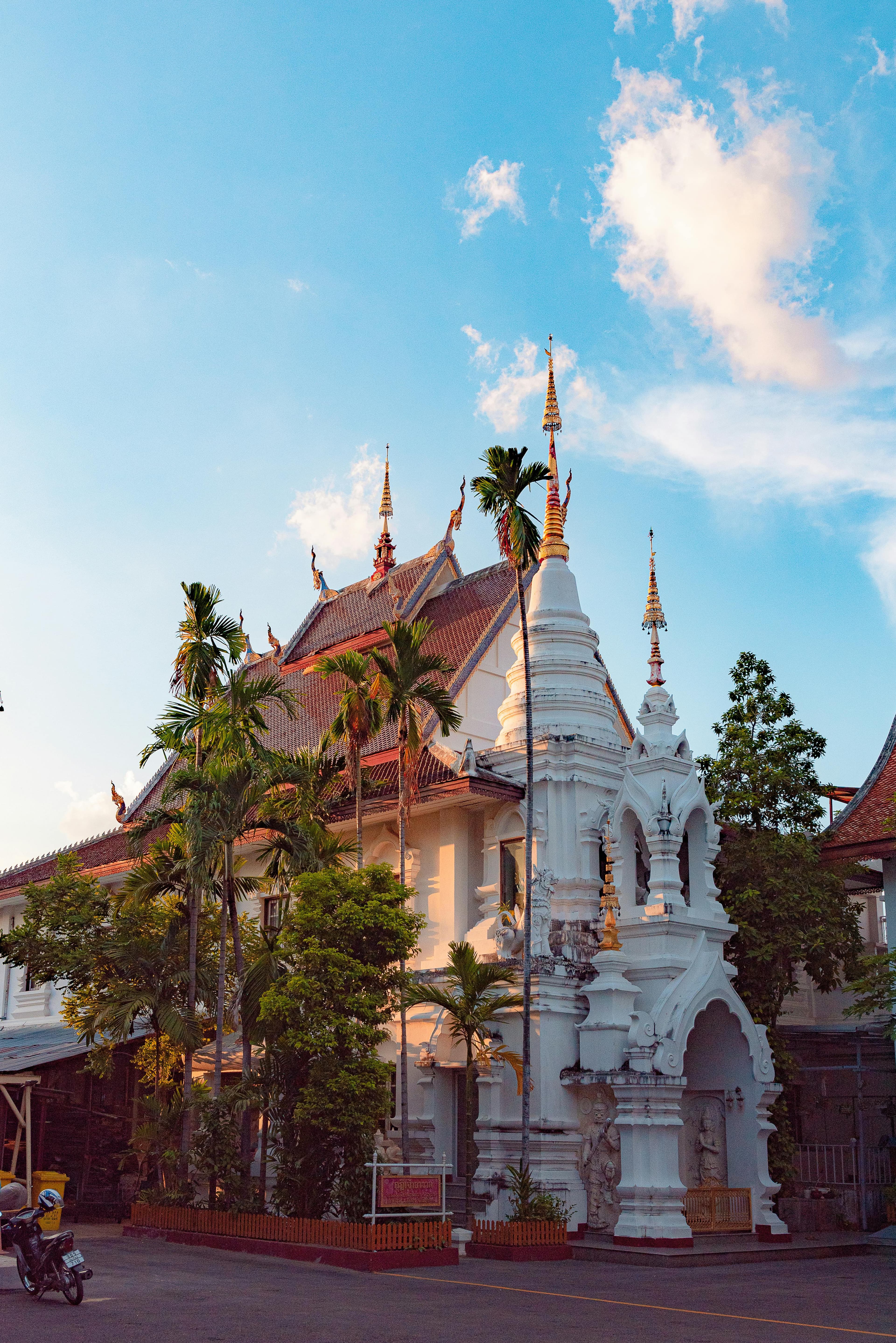 White temple with golden spires in Chiang Mai Old City at sunset