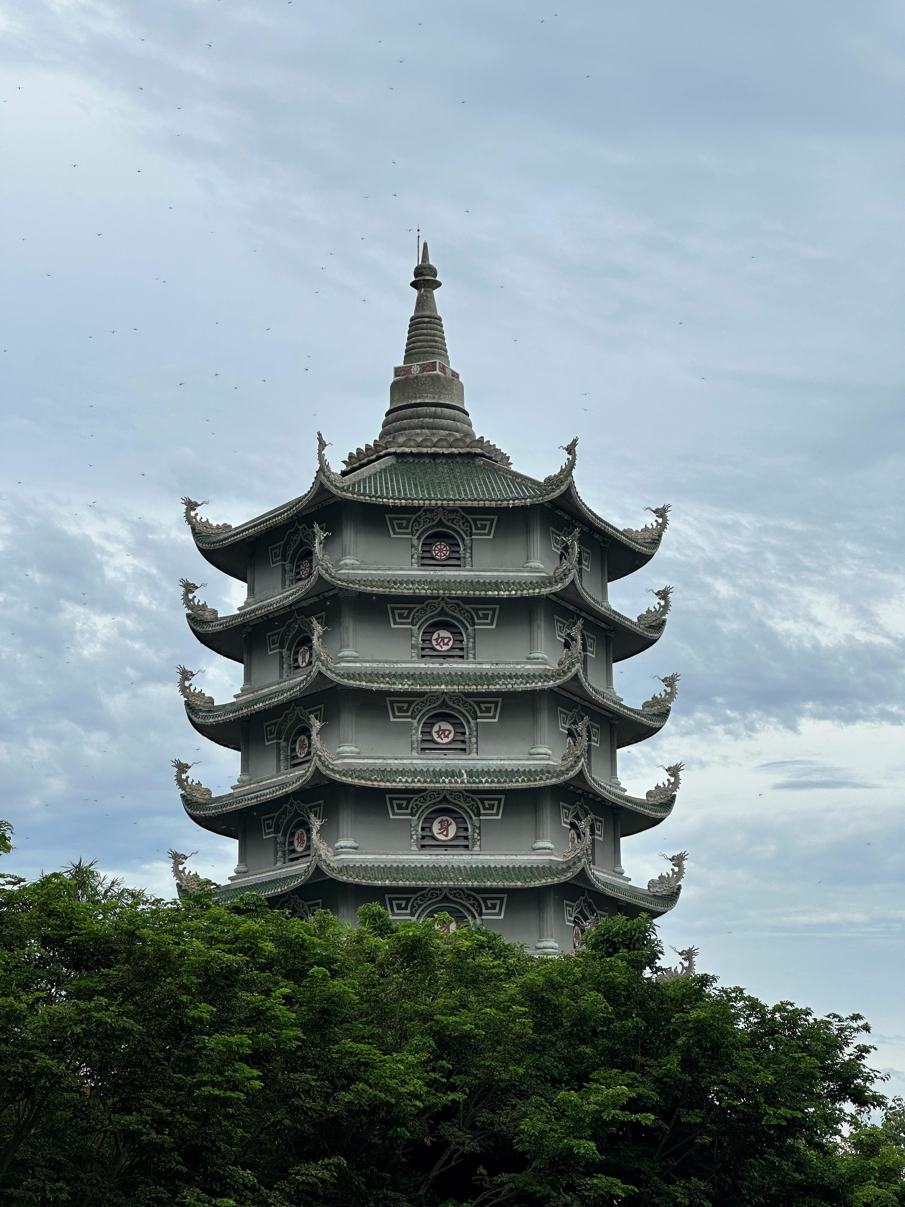 Ancient Buddhist pagoda tower rising above the trees at the Marble Mountains near Da Nang Vietnam