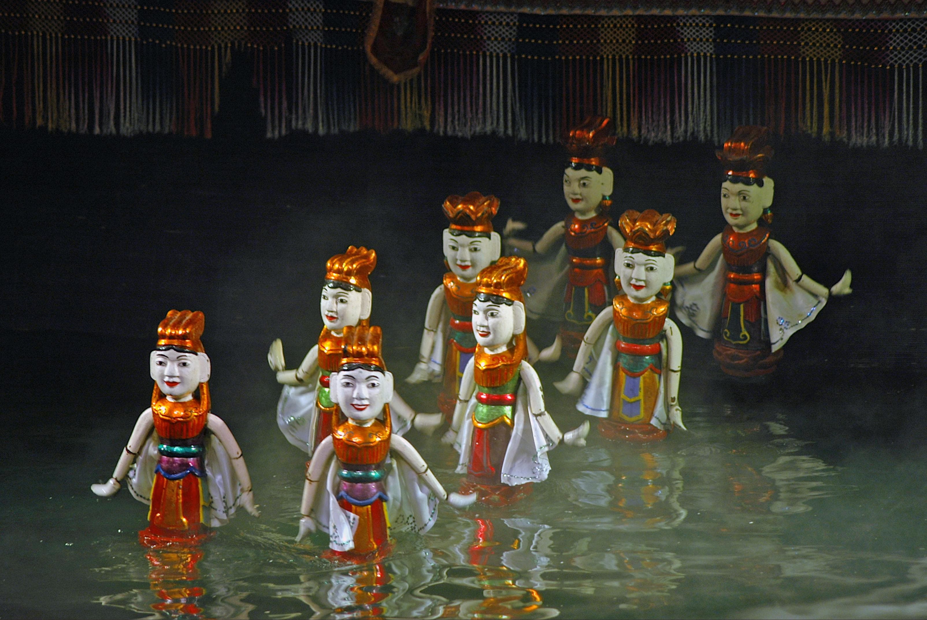 Traditional Vietnamese water puppet show performance with wooden figures