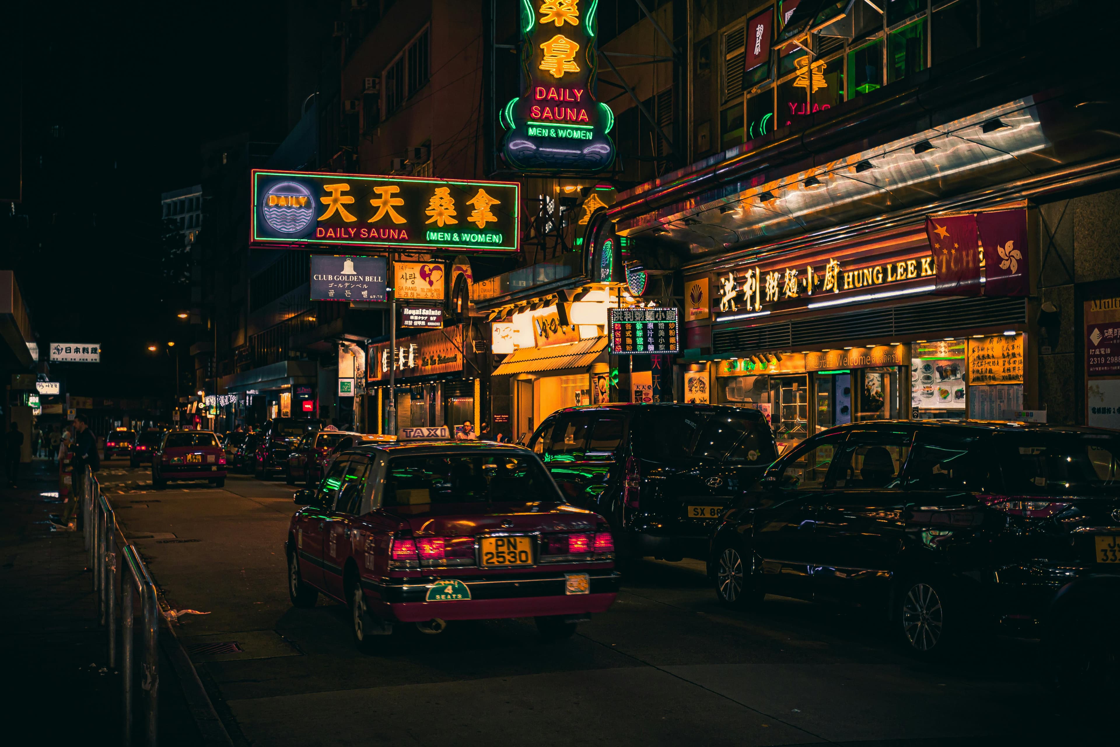 Hong Kong neon street at night taxis 2026