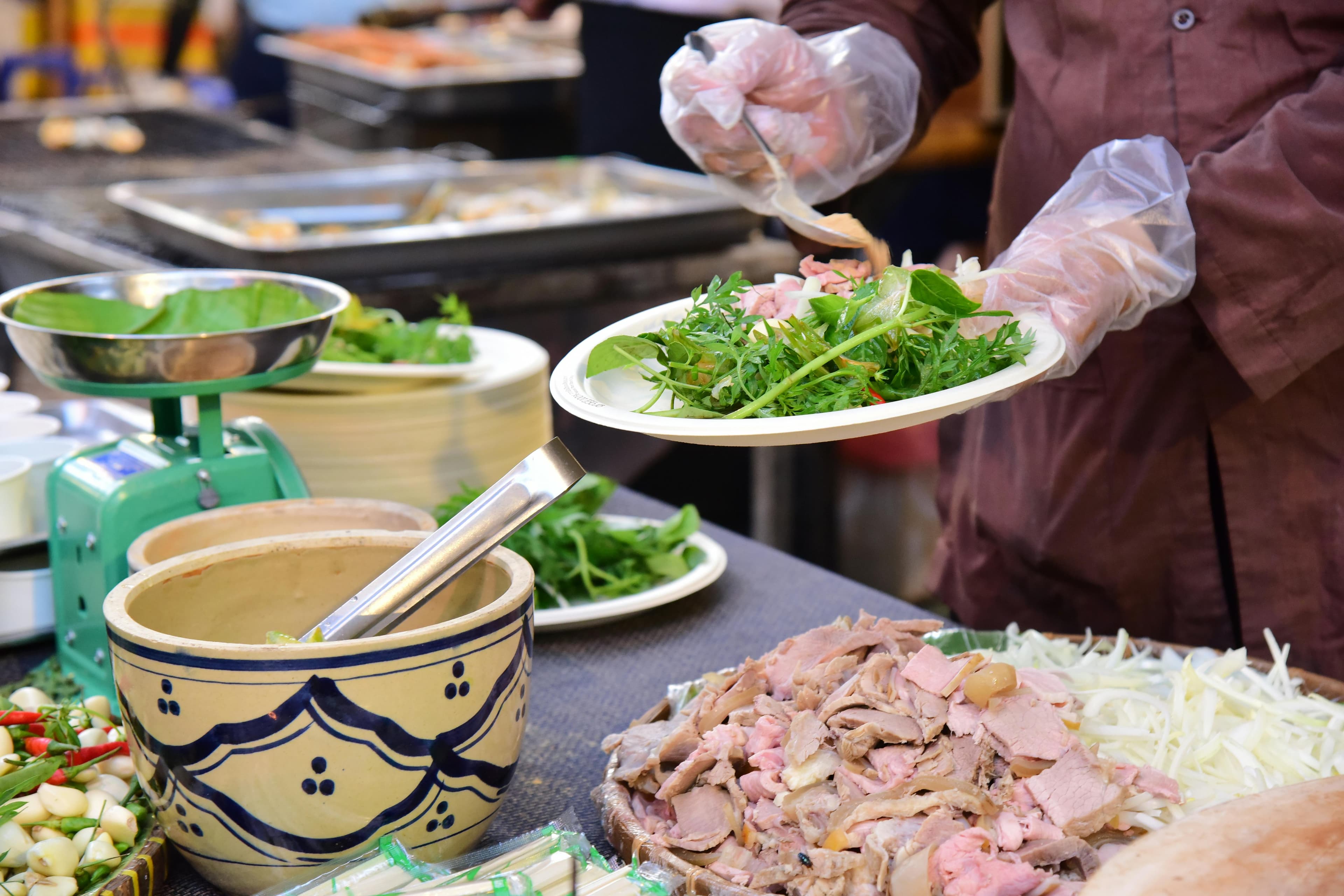 Vietnamese street food market with fresh herbs and ingredients for a Hoi An cooking class