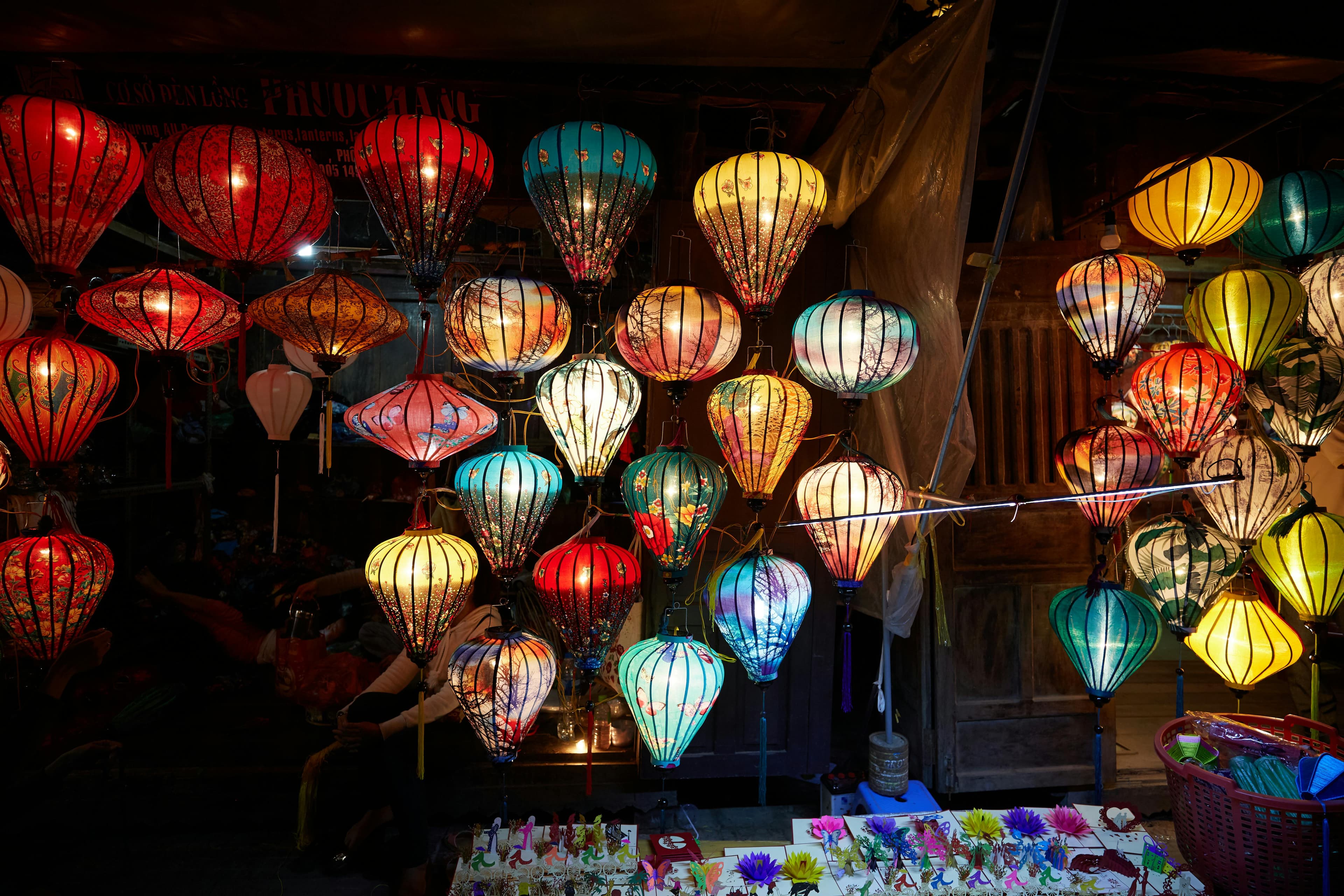 Colorful silk lanterns hanging from the ceiling in a traditional Hoi An lantern workshop