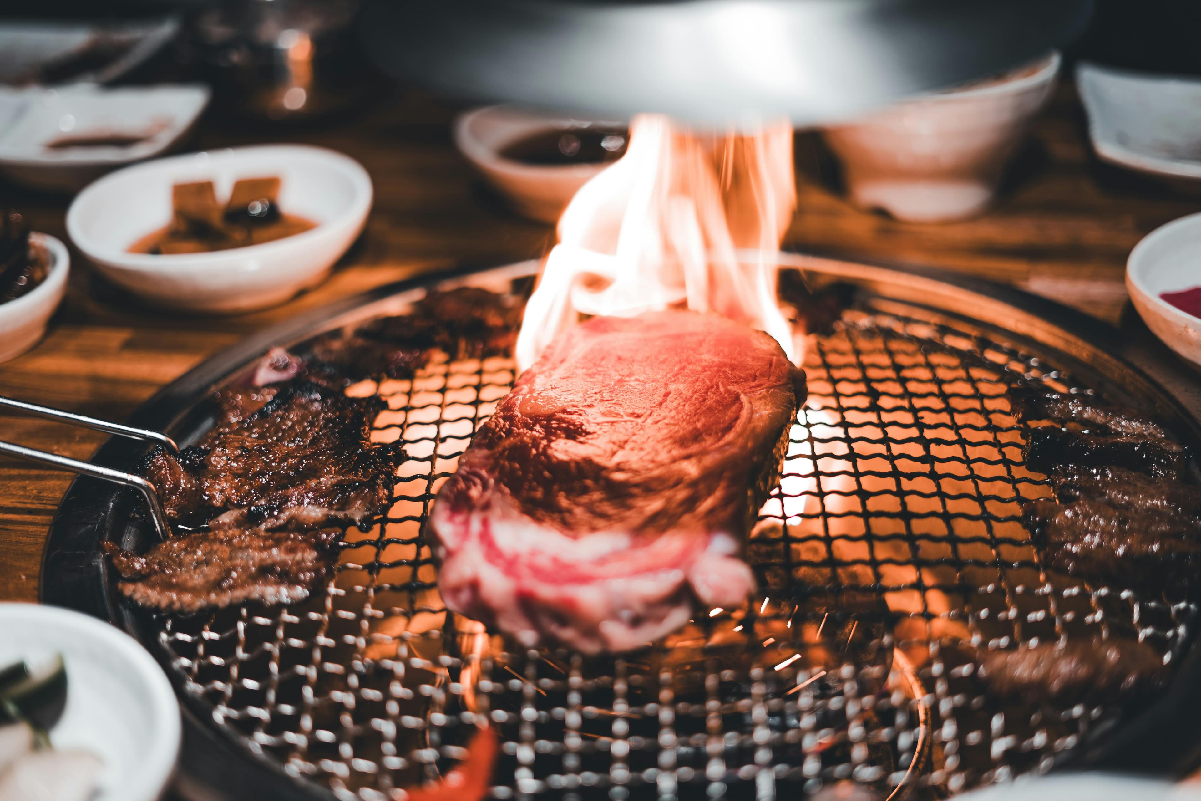 Traditional Korean BBQ setup with grilled meat, banchan side dishes, and soju in Seoul restaurant