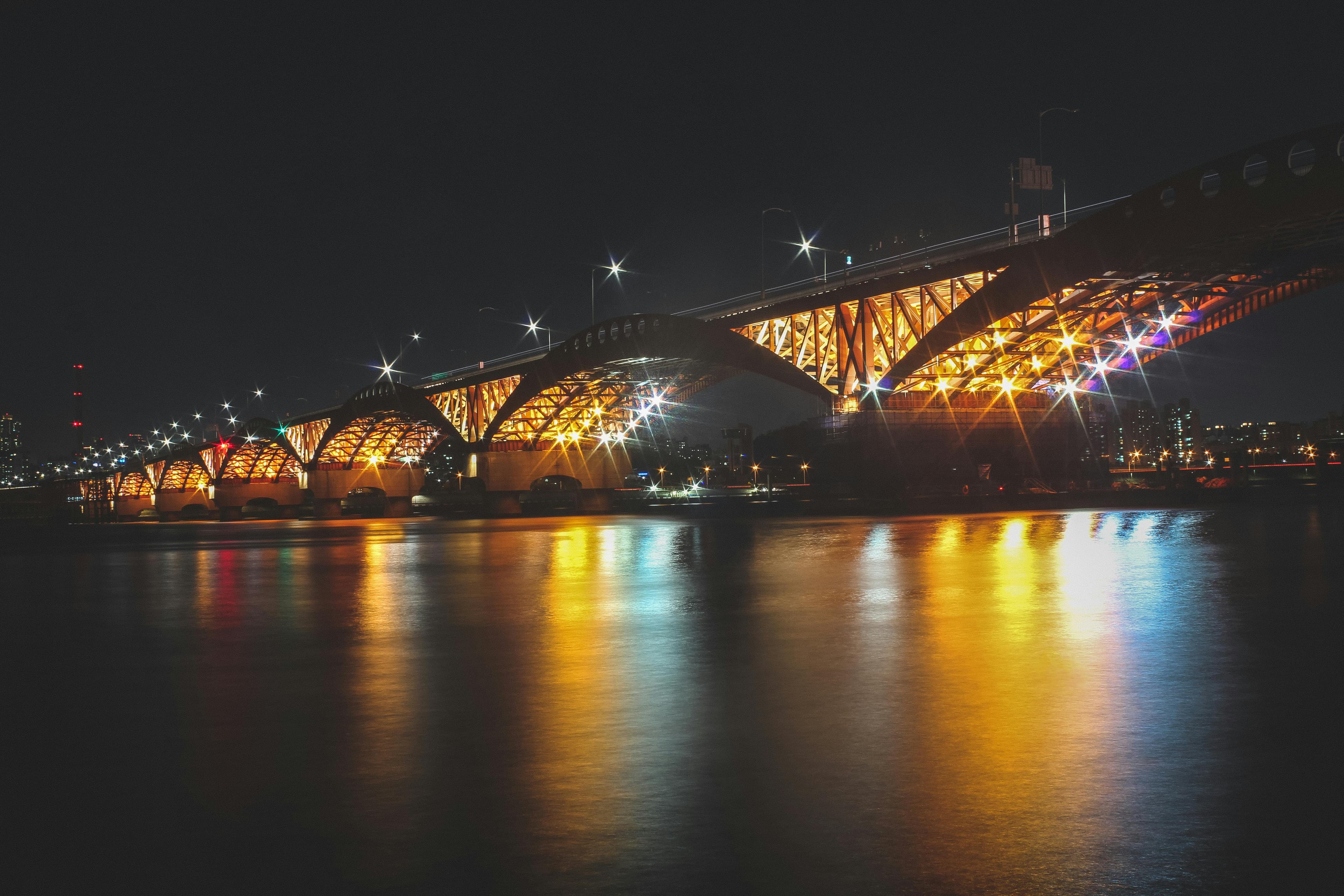 Han River cruise at night with illuminated Seoul skyline and modern bridges reflecting in water