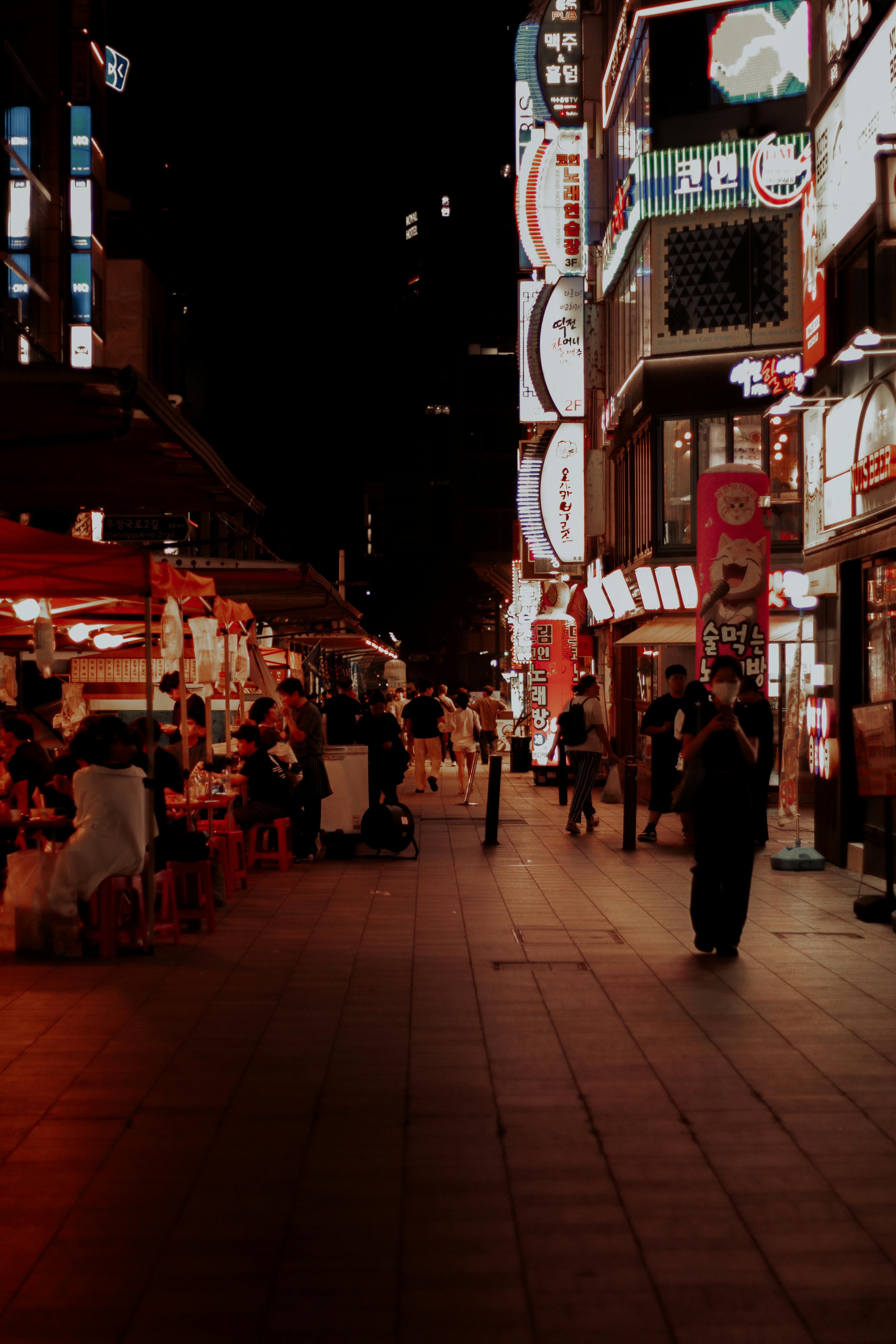 Hongdae nightlife Seoul with neon signs karaoke bars street food and young crowds at night