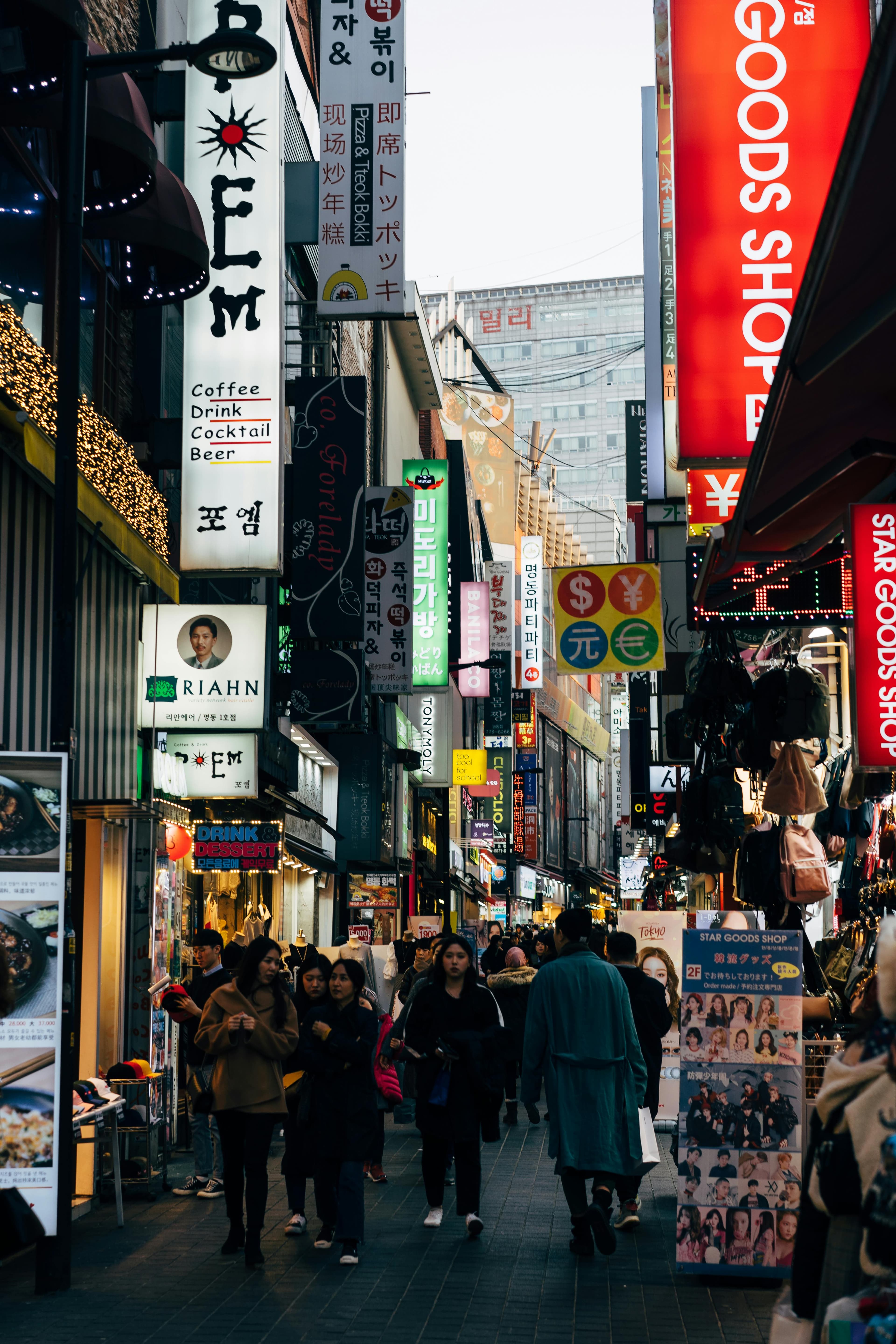 Myeongdong shopping street Seoul with K-beauty shops neon signs and street food vendors