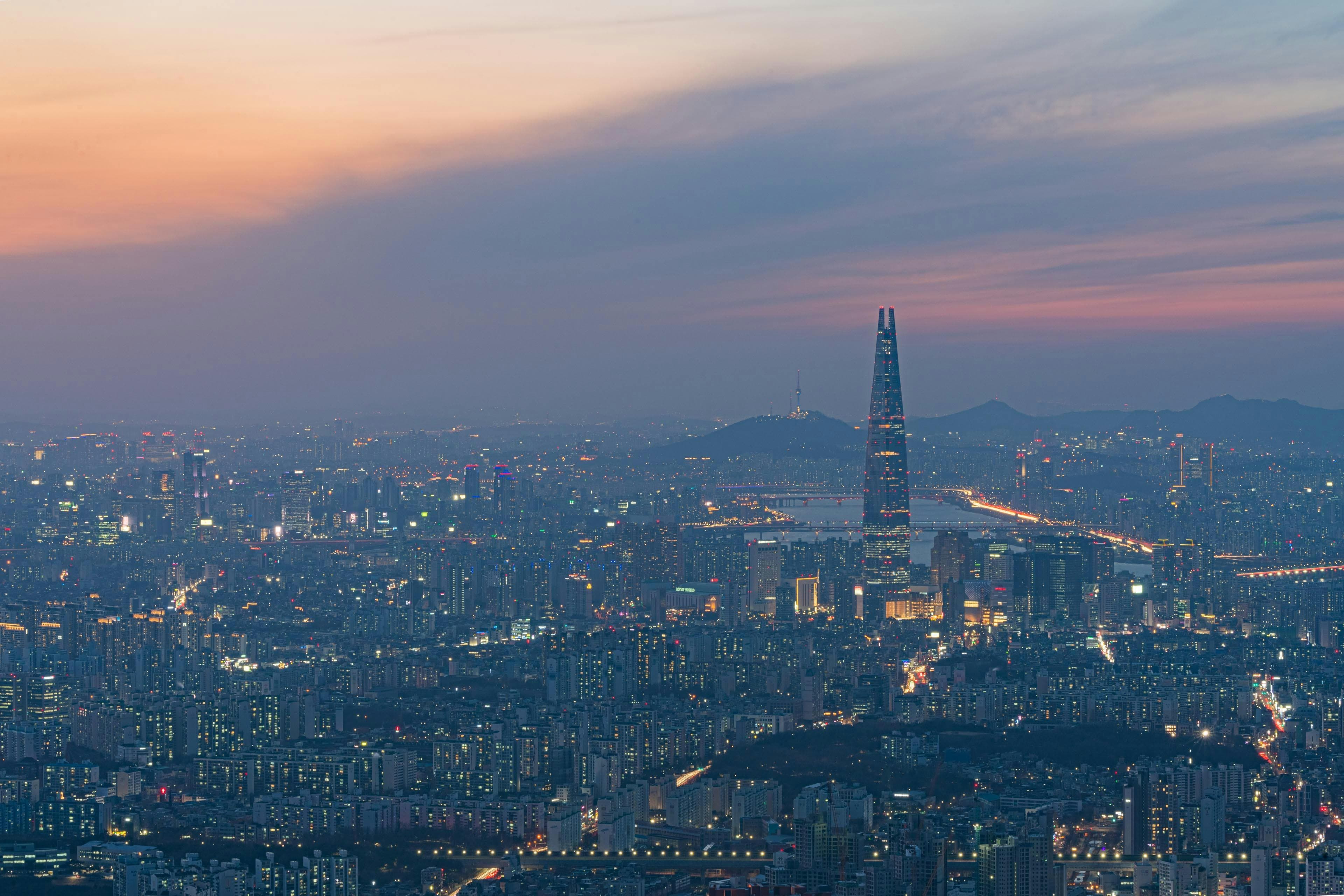 Seoul skyline at sunset with Lotte World Tower and N Seoul Tower visible across the city panorama Korea
