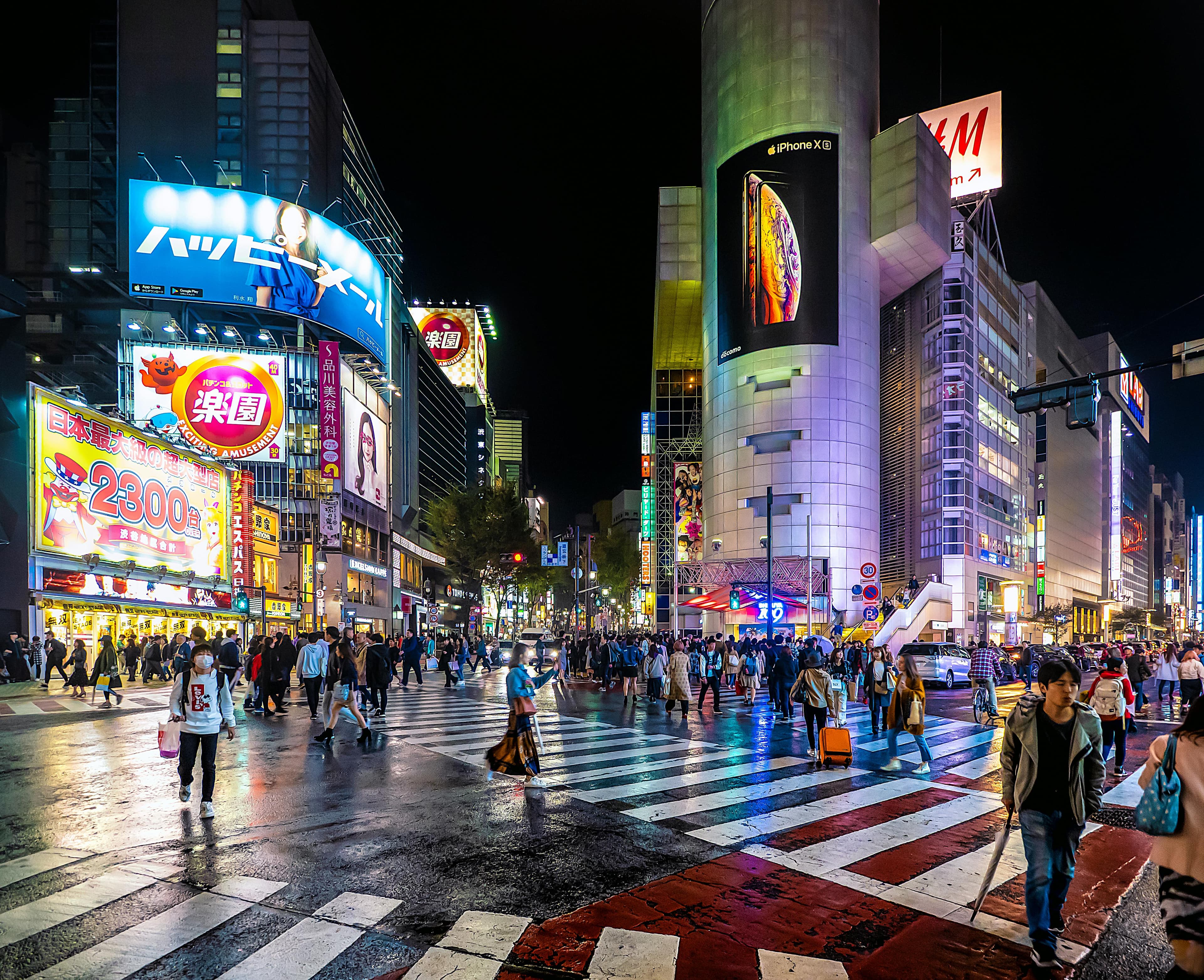 Shibuya Crossing Tokyo at night with neon signs crowds crossing and illuminated buildings